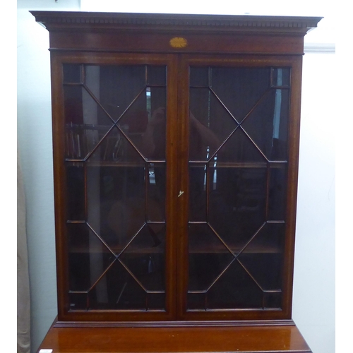 135 - An Edwardian style satinwood, string inlaid, crossbanded mahogany cabinet bookcase, the upper part e... 