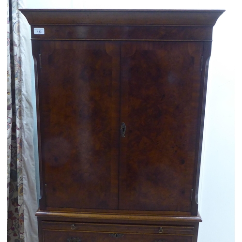 143 - A 1930s design walnut finished cocktail cabinet, the upper part enclosed by a pair of doors, over a ... 