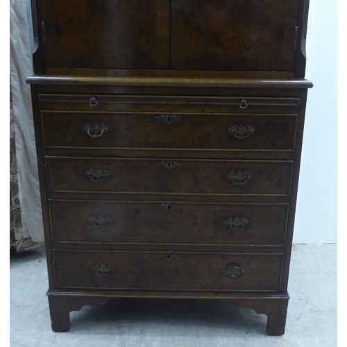 143 - A 1930s design walnut finished cocktail cabinet, the upper part enclosed by a pair of doors, over a ... 