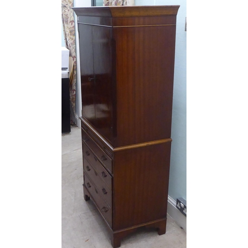 143 - A 1930s design walnut finished cocktail cabinet, the upper part enclosed by a pair of doors, over a ... 