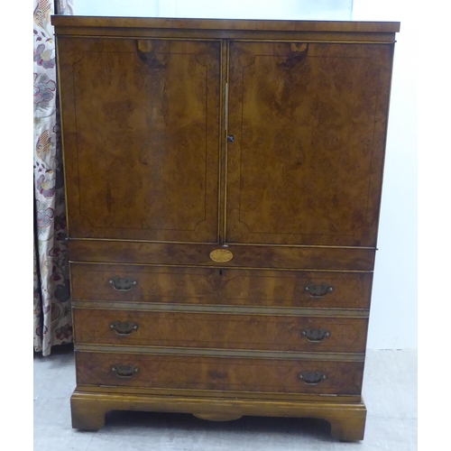 147 - A modern walnut finished hi-fi cabinet, enclosed by a pair of doors, over a fall front, featuring th... 