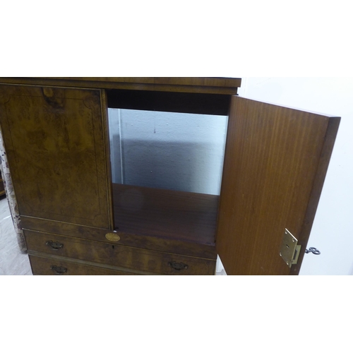 147 - A modern walnut finished hi-fi cabinet, enclosed by a pair of doors, over a fall front, featuring th... 