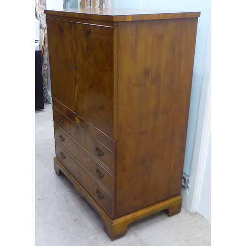 147 - A modern walnut finished hi-fi cabinet, enclosed by a pair of doors, over a fall front, featuring th... 