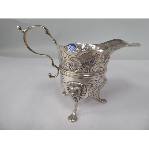 15 - A late 18th/early 19thC Irish silver cream jug of cauldron form with a flared, decoratively cut rim ... 