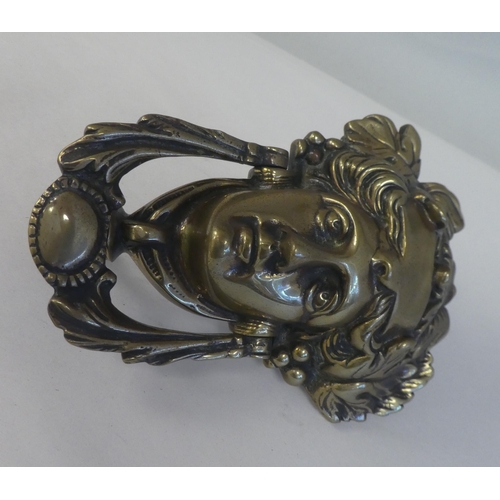 150 - An Art Nouveau period cast brass door knocker, fashioned as a female head, adorned with leaves and b... 