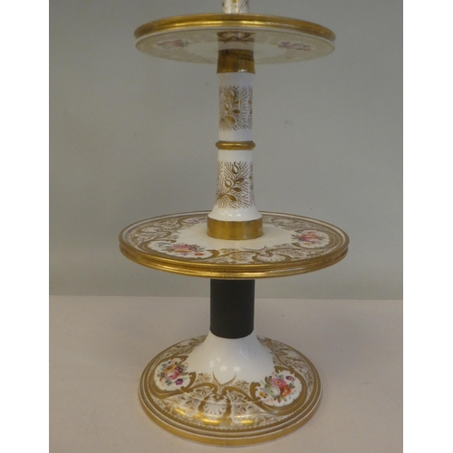 154 - A late 19thC floral painted and gilded china three tier stand, on a circular base  16