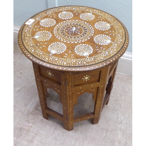 156 - An early 20thC North African hardwood side table, intricately inlaid in bone and mother-of-pearl wit... 