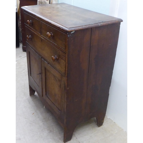 158 - An early 20thC oak cupboard, comprising two short/one long drawers, over a pair of panelled doors, r... 