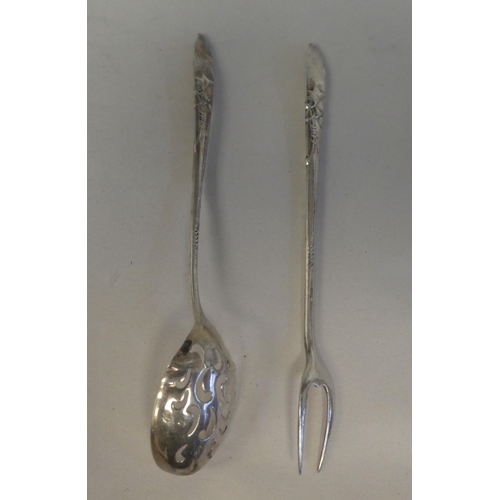 160 - A Liberty & Co silver coloured metal olive spoon and fork, on decoratively cast handles 