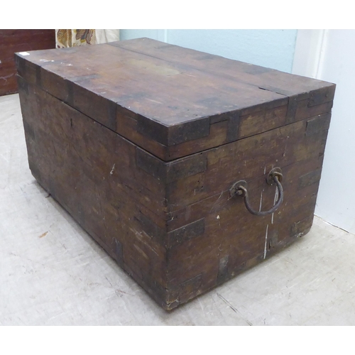 161 - A late 19thC hardwood trunk with iron brackets and flank bail handles with an inscribed brass namepl... 