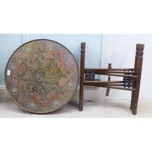 162 - An early 20thC North African coloured stained brass topped tray table, set on a folding beech stand&... 