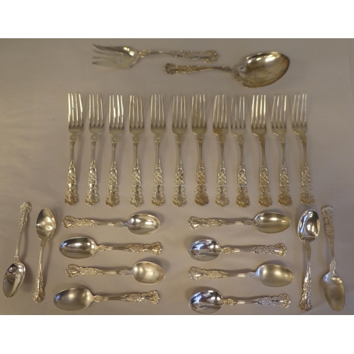 165 - Sterling silver flatware, on decoratively cast floral and scrolled handles, comprising a pair of ser... 