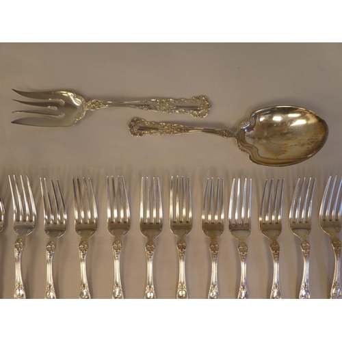 165 - Sterling silver flatware, on decoratively cast floral and scrolled handles, comprising a pair of ser... 