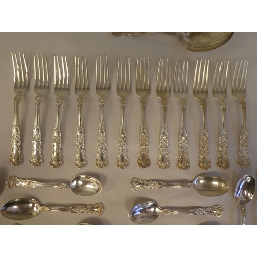 165 - Sterling silver flatware, on decoratively cast floral and scrolled handles, comprising a pair of ser... 