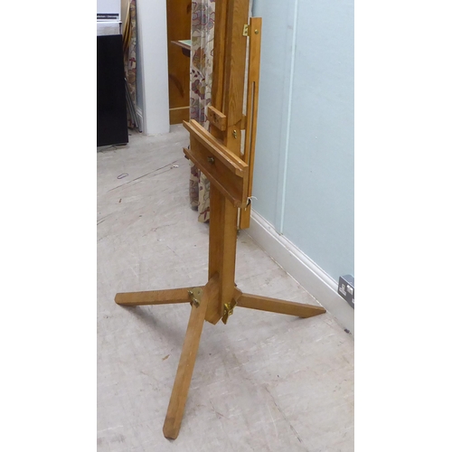 172 - A stained pine and brass mounted folding studio easel 