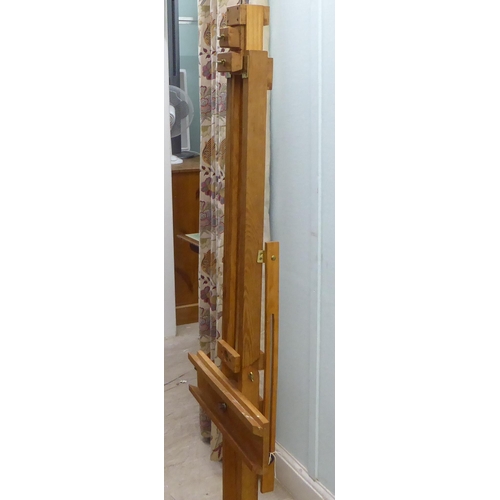 172 - A stained pine and brass mounted folding studio easel 