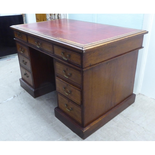 176 - A late Victorian mahogany nine drawer on a twin pedestal desk with a tooled oxblood coloured hide sc... 