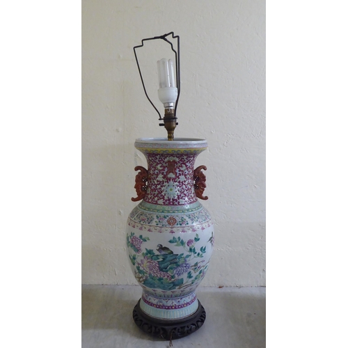 190 - A late 19thC Chinese porcelain table lamp of waisted form, decorated in pastel tones with birds amon... 