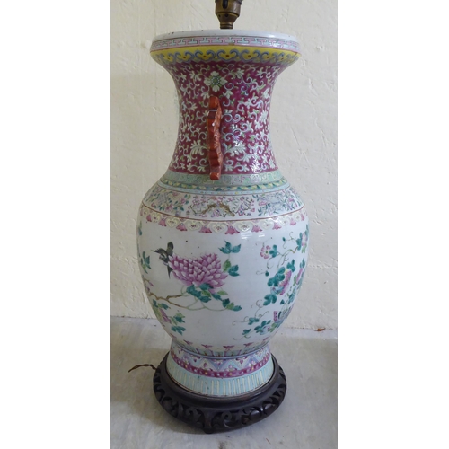 190 - A late 19thC Chinese porcelain table lamp of waisted form, decorated in pastel tones with birds amon... 