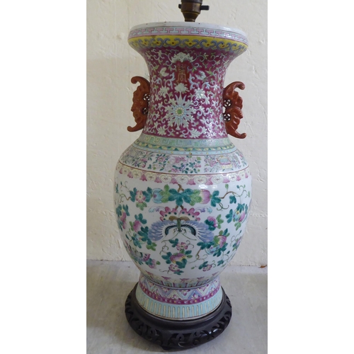 190 - A late 19thC Chinese porcelain table lamp of waisted form, decorated in pastel tones with birds amon... 