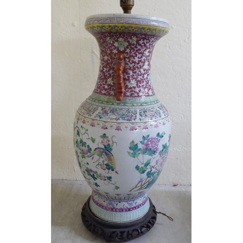 190 - A late 19thC Chinese porcelain table lamp of waisted form, decorated in pastel tones with birds amon... 