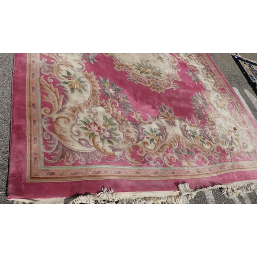 191 - A Chinese washed woollen carpet, decorated with flora in pastel colour, on a pink ground  110