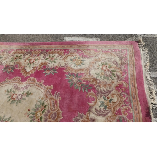 191 - A Chinese washed woollen carpet, decorated with flora in pastel colour, on a pink ground  110