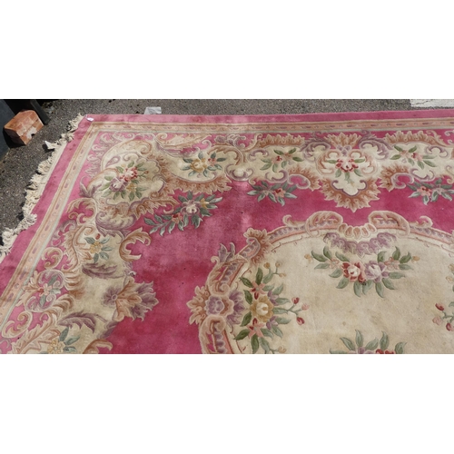 191 - A Chinese washed woollen carpet, decorated with flora in pastel colour, on a pink ground  110