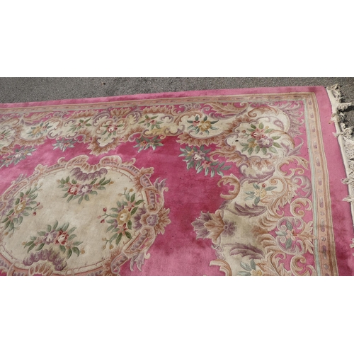 191 - A Chinese washed woollen carpet, decorated with flora in pastel colour, on a pink ground  110