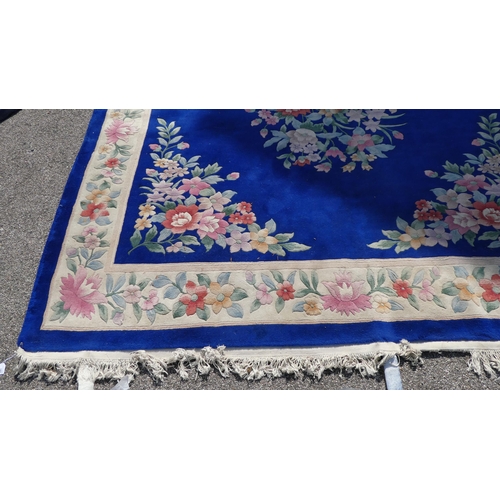 192 - A Chinese washed woollen carpet, decorated with a central floral bouquet motif, bordered by addition... 