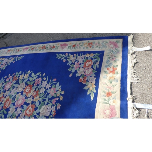 192 - A Chinese washed woollen carpet, decorated with a central floral bouquet motif, bordered by addition... 