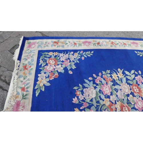 192 - A Chinese washed woollen carpet, decorated with a central floral bouquet motif, bordered by addition... 