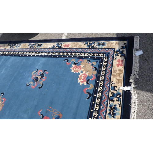 193 - A Chinese washed woollen carpet, decorated with stylised ribbon and floral designs, on a mainly two ... 