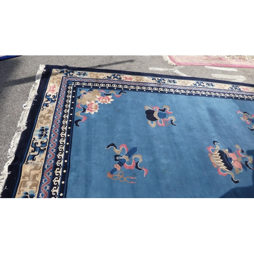 193 - A Chinese washed woollen carpet, decorated with stylised ribbon and floral designs, on a mainly two ... 