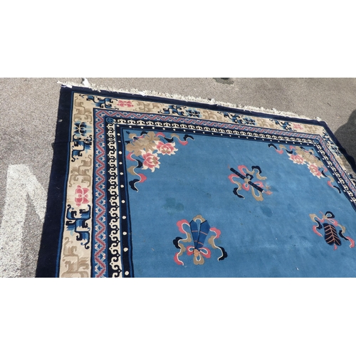 193 - A Chinese washed woollen carpet, decorated with stylised ribbon and floral designs, on a mainly two ... 