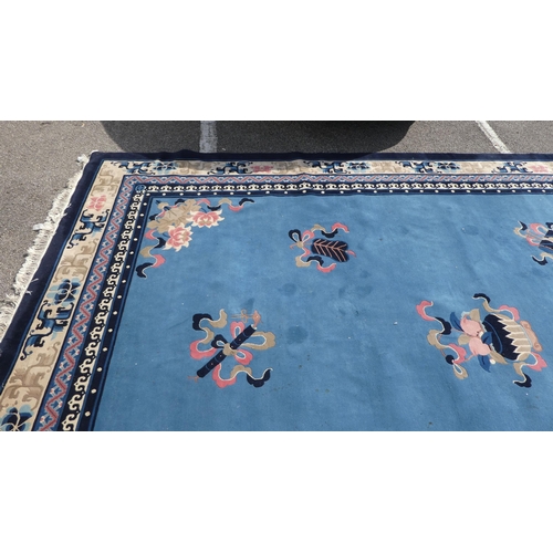 193 - A Chinese washed woollen carpet, decorated with stylised ribbon and floral designs, on a mainly two ... 