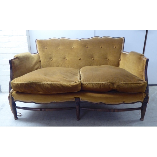 216 - An early 20thC stained beech showwood framed two person settee, upholstered in old gold/orange colou... 