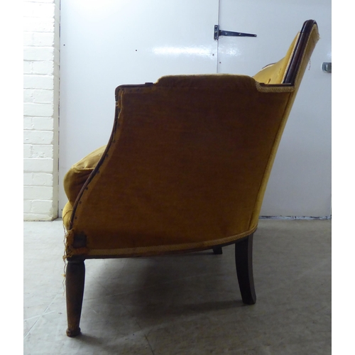 216 - An early 20thC stained beech showwood framed two person settee, upholstered in old gold/orange colou... 