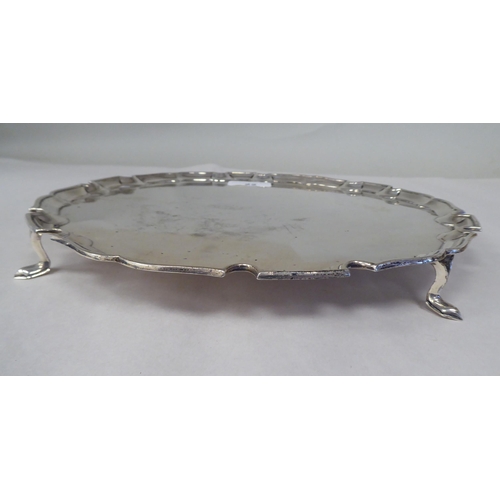 22 - A silver salver with a raised piecrust border, elevated on hoof feet  SB&S  London 192... 