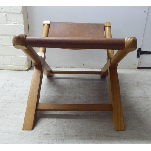 221 - A modern light oak framed and hide panelled stool 