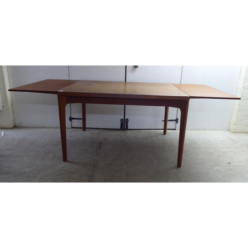 223 - A circa 1970s teak draw leaf dining table by Henning Kjærnulf for Vejle Stole Mobelfabrik of Denmark... 