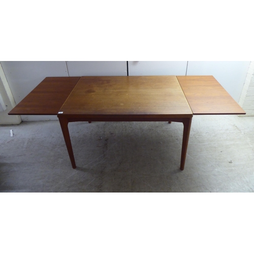 223 - A circa 1970s teak draw leaf dining table by Henning Kjærnulf for Vejle Stole Mobelfabrik of Denmark... 