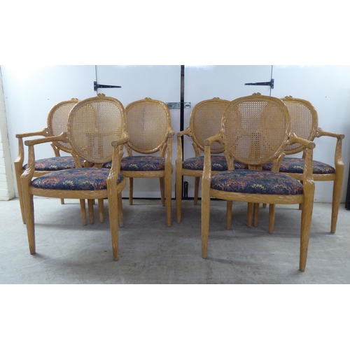 246 - A set of six modern natural oak effect framed dining chairs with a caned panel back, over a fabric c... 