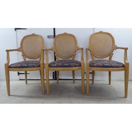 246 - A set of six modern natural oak effect framed dining chairs with a caned panel back, over a fabric c... 