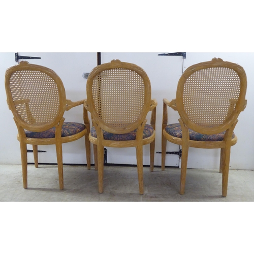 246 - A set of six modern natural oak effect framed dining chairs with a caned panel back, over a fabric c... 