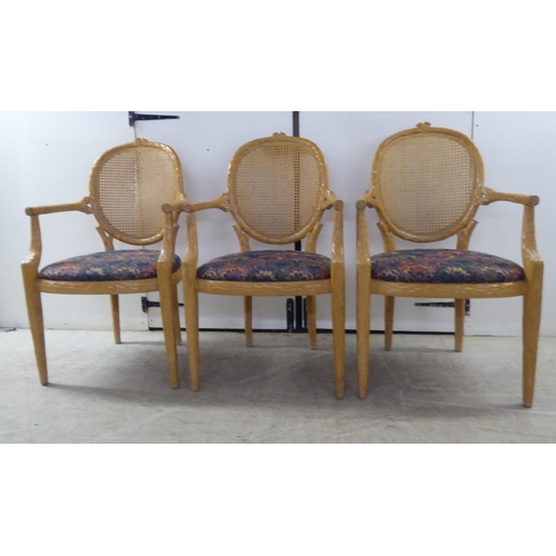 246 - A set of six modern natural oak effect framed dining chairs with a caned panel back, over a fabric c... 