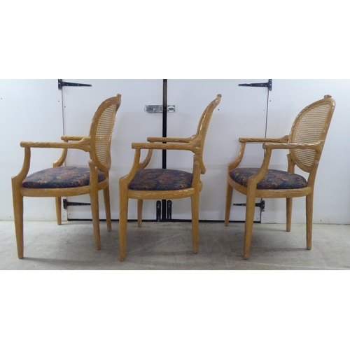 246 - A set of six modern natural oak effect framed dining chairs with a caned panel back, over a fabric c... 