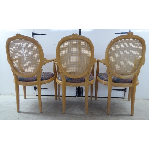 246 - A set of six modern natural oak effect framed dining chairs with a caned panel back, over a fabric c... 