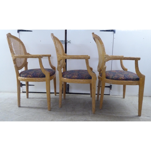 246 - A set of six modern natural oak effect framed dining chairs with a caned panel back, over a fabric c... 