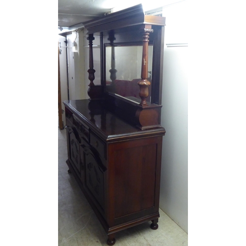 250 - A modern reproduction of a Victorian mahogany dresser, the superstructure with a bevelled mirror pan... 